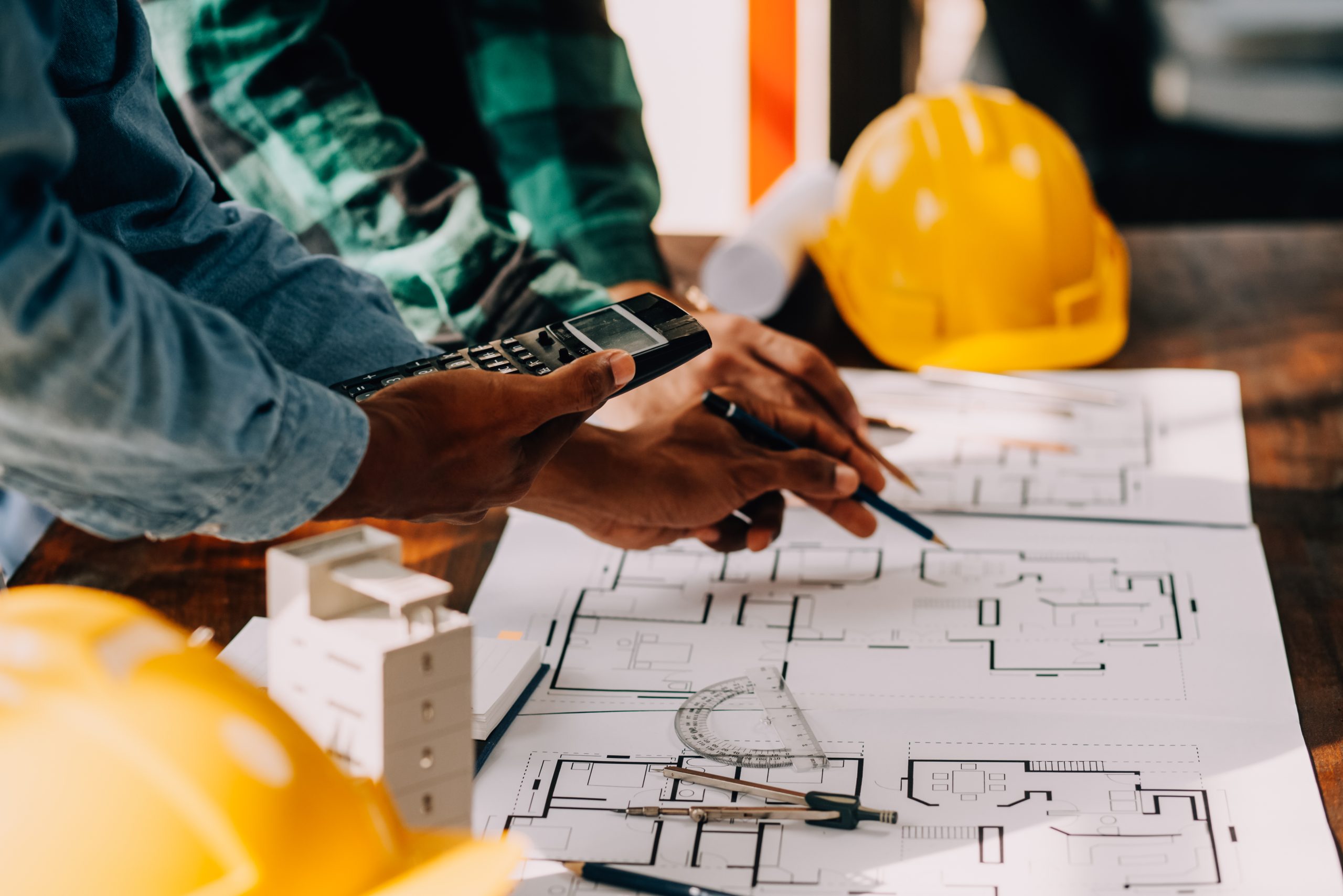 Construction and structure concept of engineer working drawing on blueprint meeting for project working with partner on model building and engineering tools in working site, construction concept.
